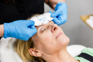 A woman shuts her eyes and reclines while she receives facial rejuvenation near Kill Devil Hills.