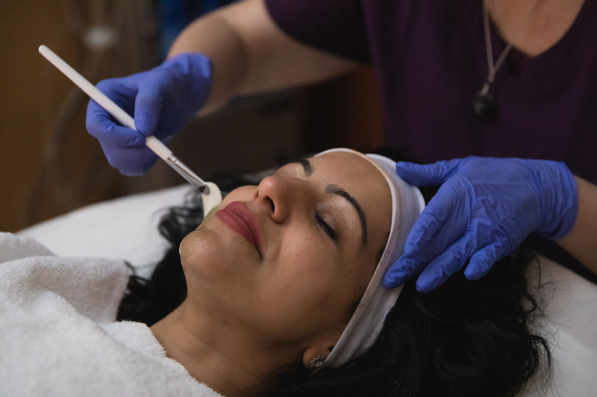 A woman receiving her monthly facial at BeachGlo Aesthetics after learning how to get rid of wrinkles in Nags Head.