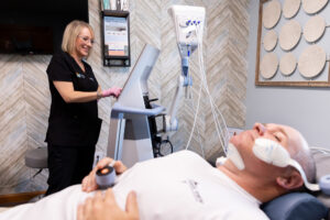 A male BeachGlo Aesthetics patient lies on a treatment bed during his appointment for Emface near Kitty Hawk.