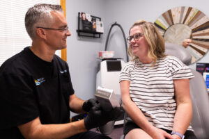 A provider smiles with a patient as he explains radiofrequency for skin near Kill Devil Hills.